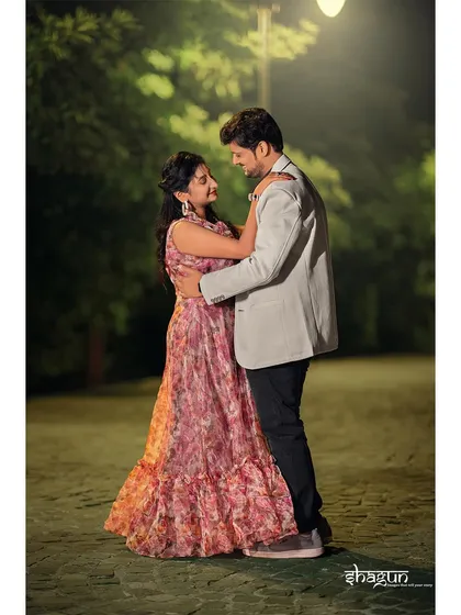 A slow dance in the park at night. The soft, diffused lighting creates a dreamy, magical atmosphere for this romantic pre-wedding photograph.