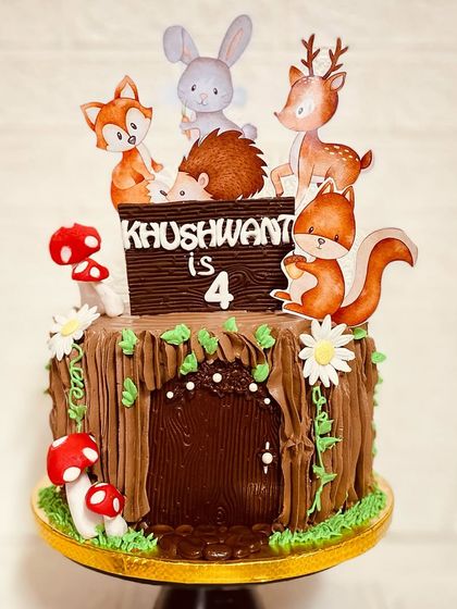 Welcome to the woods. This choco-vanilla woodland-themed cake features a tree stump design and is topped with cute forest animals like a fox, deer, and rabbit.
