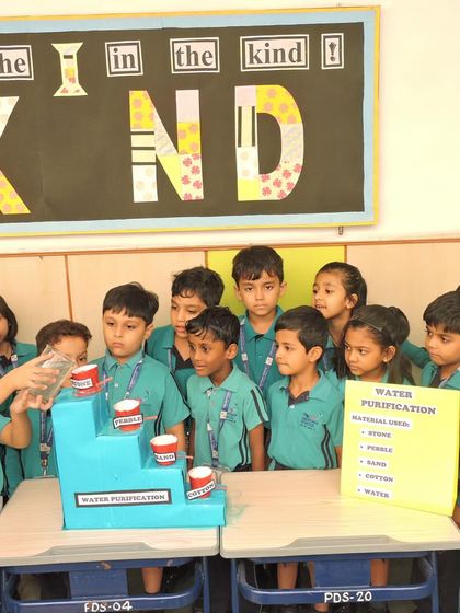 A group of curious students gathers to observe a water purification experiment. We use practical demonstrations like this to teach important environmental science concepts and the value of clean resources.
