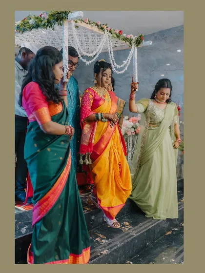 The bride's entrance in a vibrant yellow and pink Nauvari saree, a beautiful moment of anticipation.