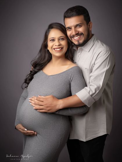 A happy and relaxed couple portrait. Their bright smiles and easy embrace show the joy they share, captured in a simple and modern studio style.