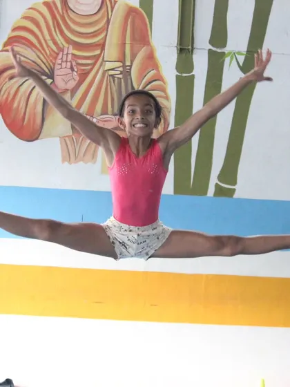 A dynamic split leap captured mid-air. This photo shows the power and grace we cultivate in our artistic gymnastics program.