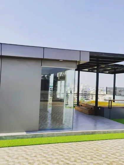 A view of the modern terrace room, constructed with sleek composite panels and large glass doors for a seamless connection to the outdoors.