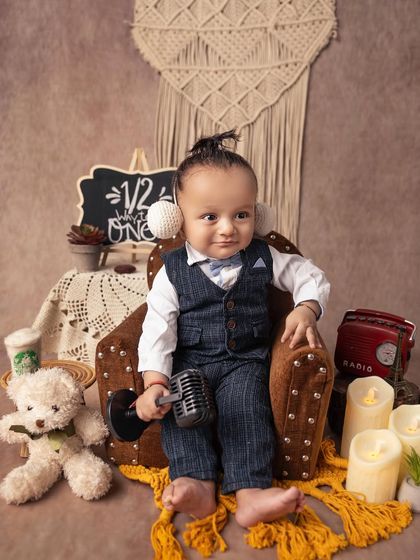 Ready to make a call on his tiny microphone prop. This playful shot from a sitter session perfectly captures the curious and interactive nature of babies at this age.