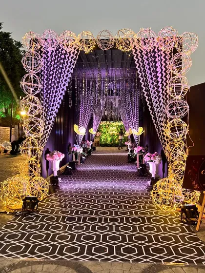 A wider view of the illuminated sphere entrance, leading to the main event area.
