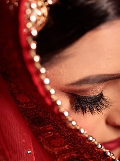 A detailed shot of the eye makeup. The focus is on long, feathery lashes and a perfectly blended shadow to create a look that is both dramatic and soft.