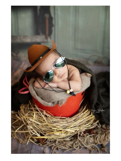 This little cowboy is sleeping on the job, and we don't mind one bit. The combination of the rustic props and the baby's peaceful expression makes for a perfect shot.