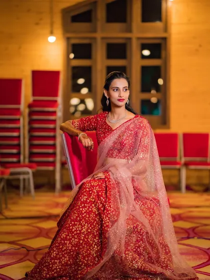 A seated portrait of my client at her brother's engagement. The soft lighting highlights her flawless makeup and the elegant drape of her saree, creating a look of pure sophistication.