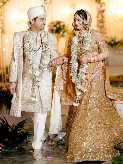 A classic portrait of the bride and groom walking hand-in-hand after their ceremony.