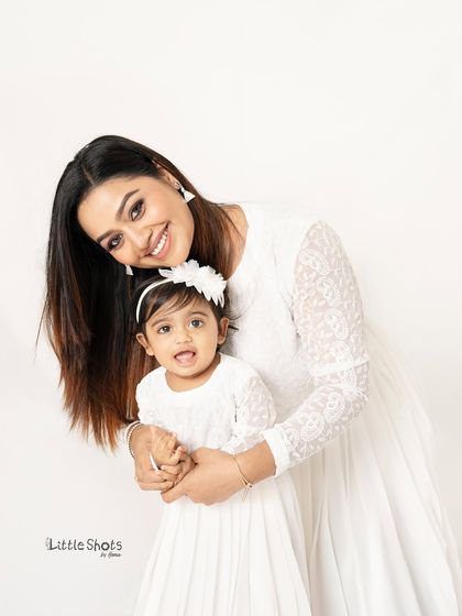 Another adorable shot of a mother and daughter in matching white dresses, sharing a hug. These are the precious moments that make for beautiful memories.