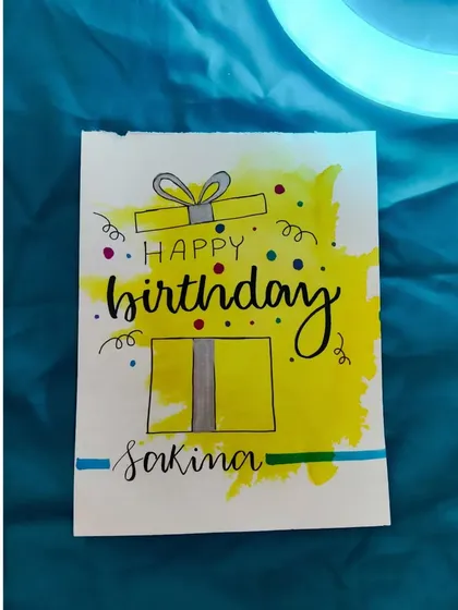 An idea for a simple and cute birthday card, featuring a yellow gift box and hand-lettered name.