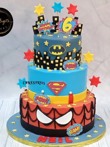 A massive three-tier superhero cake for a 6th birthday. This 5kg black forest cake features Spider-Man, Superman, and Batman tiers with bold colors and logos.