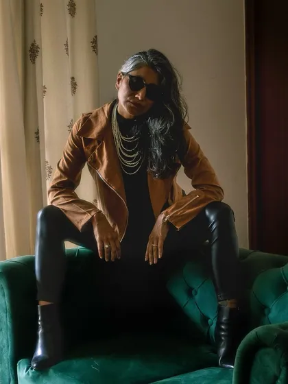 A powerful 'Chief Execution Officer' pose. The combination of a biker jacket, leather-look pants, and pearls creates a look that is both strong and stylish.