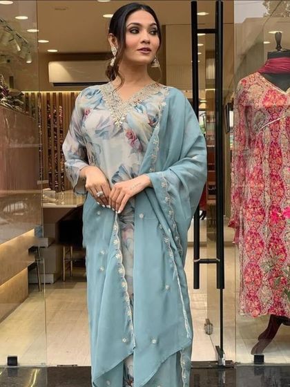 A grey premium organza kurta with a soft floral print. The delicate thread embroidery on the neckline adds a touch of elegance.