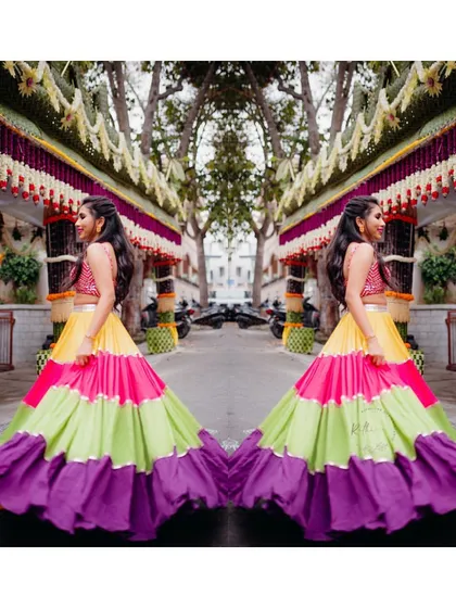 A creative shot of our bride twirling in her multi-colored tiered lehenga, showcasing the beautiful flow and vibrant colors of the skirt.