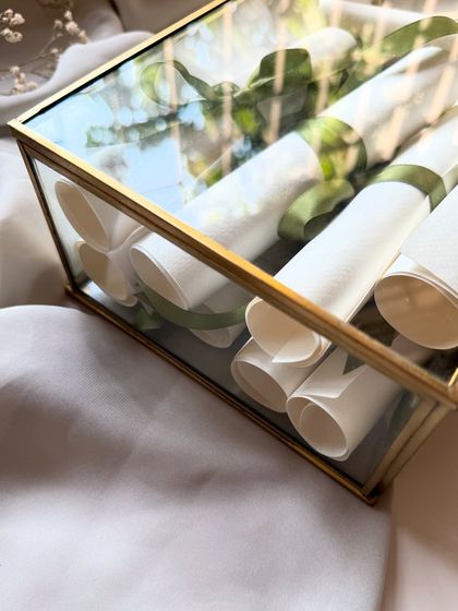 A close-up of the glass keepsake box filled with handwritten vow scrolls. This is a beautiful way to store and display the most important words you'll ever exchange.