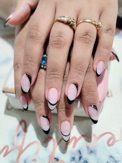 A sleek and graphic look, these long almond nails feature a deep black French tip with a sharp, modern curve.