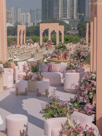 The sprawling setup of our 'Handpainted Story' wedding, showcasing different seating zones against the urban skyline of Mumbai.