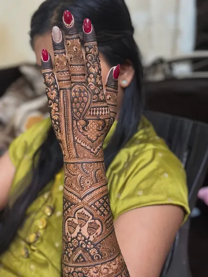 A student holding up her arm after I completed a demo on her. This gives a real-life perspective of how a full bridal design looks on the arm.