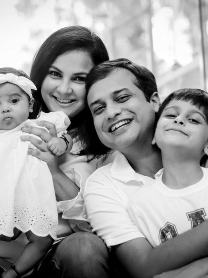 A happy family of four posing on the stairs of their home's exterior. A great example of a lifestyle shoot at home.