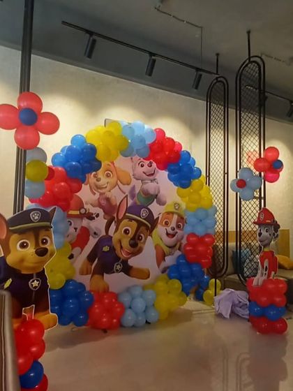 A classic Paw Patrol theme is always a hit with the kids. This setup features a circular backdrop with the whole pup squad, framed by a primary-colored balloon arch and character standees.