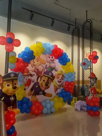 A classic Paw Patrol theme is always a hit with the kids. This setup features a circular backdrop with the whole pup squad, framed by a primary-colored balloon arch and character standees.