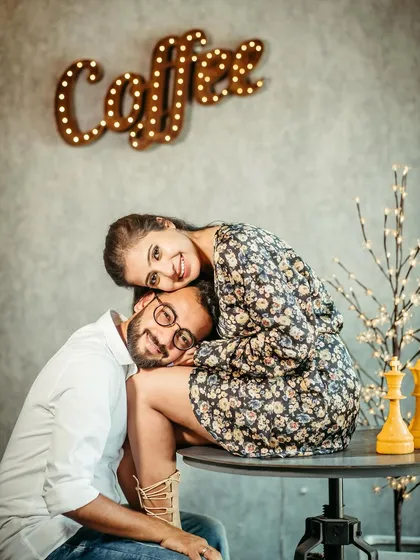 A fun and stylish coffee shop scene. The makeup is chic and modern, fitting the trendy vibe of the location.