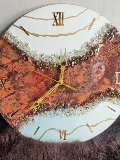 This geode-style clock features a warm, fiery orange and brown center, creating a bold and dramatic look.