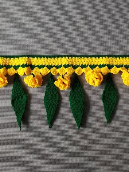A simple and elegant toran with yellow flowers and green leaves, perfect for adding a touch of tradition to your home.