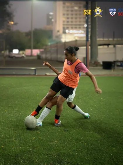 A player shields the ball from an opponent during a competitive drill. We train our girls to be strong and confident in possession, a crucial skill in modern football.