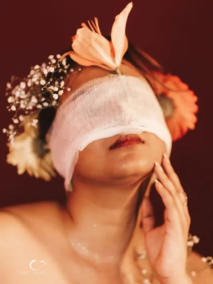 A beautiful and artistic close-up. The textures of the flowers, the gauze, and her skin create a visually rich portrait.