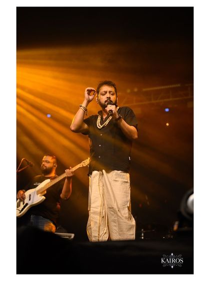 A full-length shot of a singer performing in traditional attire, showing the entire stage presence and atmosphere of the concert.