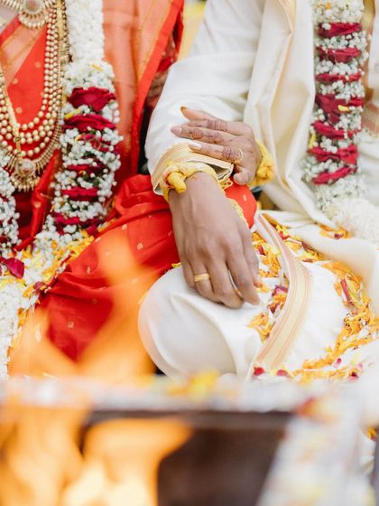 A close-up of the couple's hands during the sacred fire ceremony. This shot focuses on the ritual's details, symbolizing their union witnessed by the holy fire.