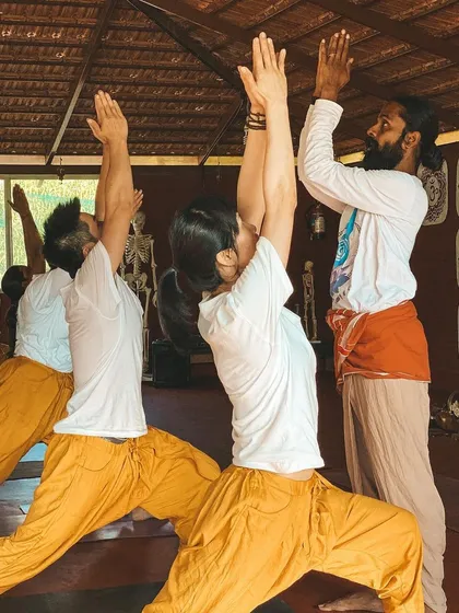 I provide a gentle adjustment in Warrior I, ensuring the student's alignment is correct to maximize the pose's benefits and prevent injury. This attention to detail is what we pass on to our teachers.