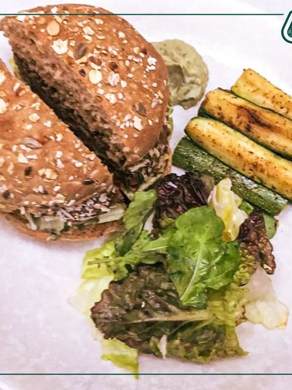 A complete meal featuring a multigrain sandwich, grilled zucchini, and a side salad. We ensure every plate is balanced with protein, healthy fats, and complex carbohydrates.