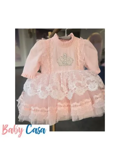 A beautiful pink lace and tulle dress with a crown emblem, fit for a little princess. This piece showcases the luxury and elegance of our designs.