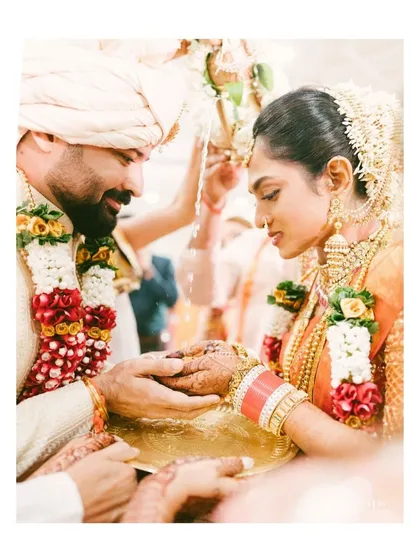 A tender moment during a traditional Indian wedding ceremony. The groom's gentle touch and the bride's serene expression are captured in this intimate and emotional photograph.
