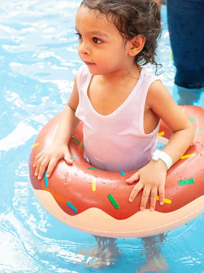 A sweet little one stays afloat with a fun, donut-shaped ring. I provide a variety of floats and swim aids to make sure even the smallest guests feel comfortable in the water.