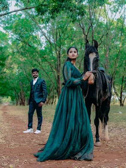 A wide shot showing the couple and their horse in a beautiful forest clearing. This kind of pre-wedding shoot is an adventure in itself.