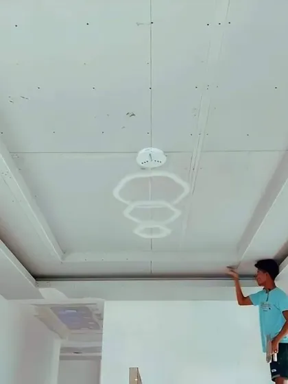 A simple and clean false ceiling with beams, shown before the final finishing. This style is great for adding a sense of structure to a room.