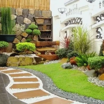 We designed this curved garden path using large pavers and decorative white pebbles. The path is flanked by a multi-level rock garden and a variety of shrubs, creating a dynamic and visually interesting journey through the space.