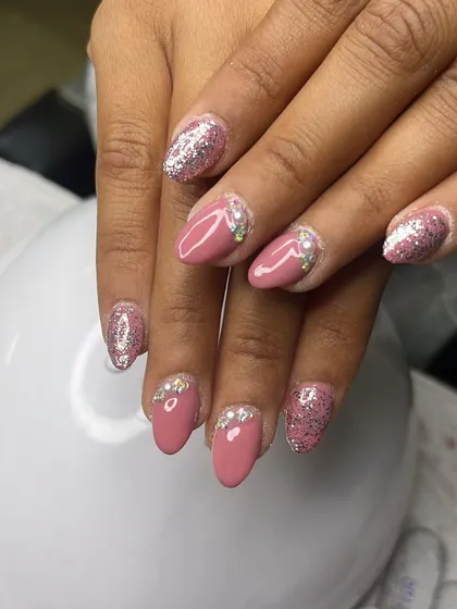A chic combination of solid dusty rose polish with accent nails in pink glitter and delicate silver rhinestones at the cuticle.