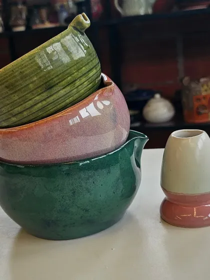 A stack of colorful matcha bowls and a whisker stand. I can create these in a wide range of beautiful glazes to suit your taste.