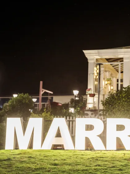 The perfect proposal setup. Large, illuminated 'MARRY ME' letters on a lawn at night create a magical and unforgettable backdrop for a proposal or pre-wedding shoot.