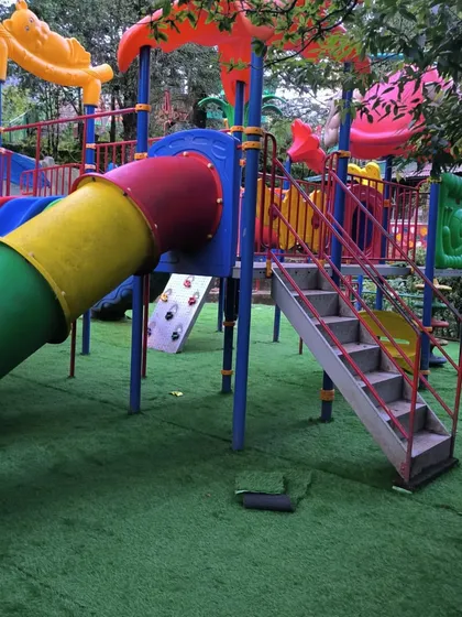 A complete view of the play structure at Nainital, now grounded in a safe and evergreen artificial lawn.
