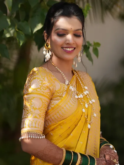 A glowing bride on her Haldi day. The beauty of a well-draped saree is how it frames the face and complements the entire look, making every moment picture perfect.