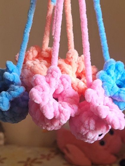 A work-in-progress shot of my octopus keychains hanging to dry. I make them in a variety of soft colors like baby blue, pink, and peach.