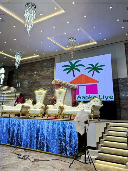 The stage at our Karjat venue is fully equipped for a grand event, featuring a large LED screen for custom backdrops and presentations. The ornate white and gold thrones provide a regal seating option for the guests of honor.