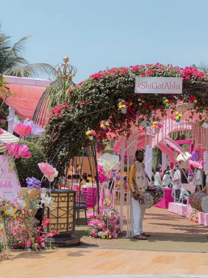 The main entrance for the pastel Haldi, featuring a large floral arch with the couple's wedding hashtag.