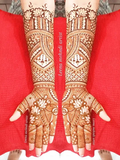 This full-coverage design for a bride is filled with lotus motifs and detailed geometric patterns. The symmetry across both hands creates a balanced and harmonious look, extending beautifully up the forearms.